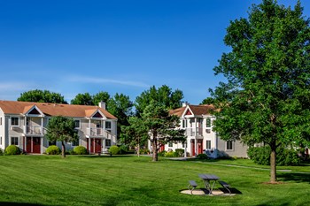 Exterior View of Apartments with Outdoor Picnic Table and Green Space. - Photo Gallery 2