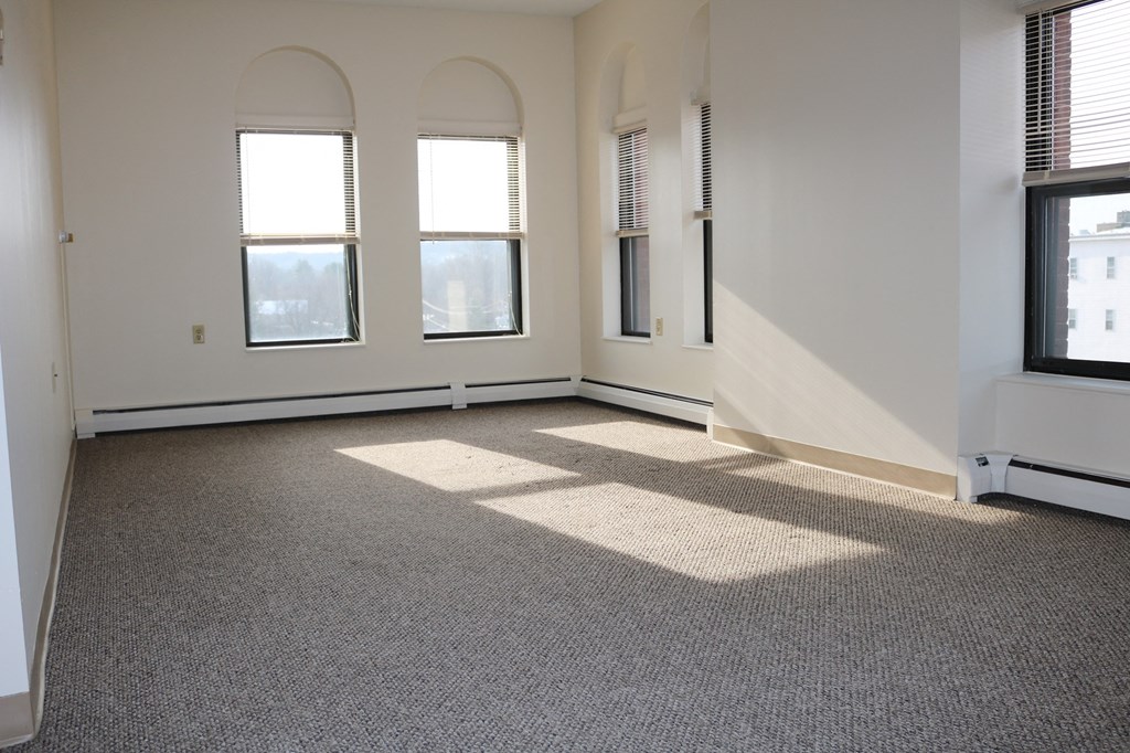 Living Room With Large Windows and Carpet at Pequoig House in Athol, MA.