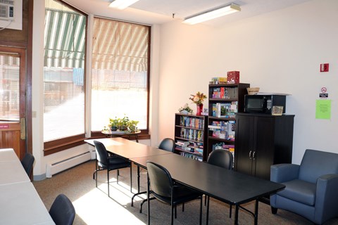Community Room With Table and Seating at Pequoig House in Athol, MA.