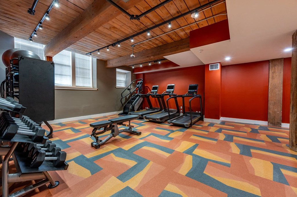 A gym with a wooden ceiling and a treadmill at The Cordovan at Haverhill Station, Haverhill, MA