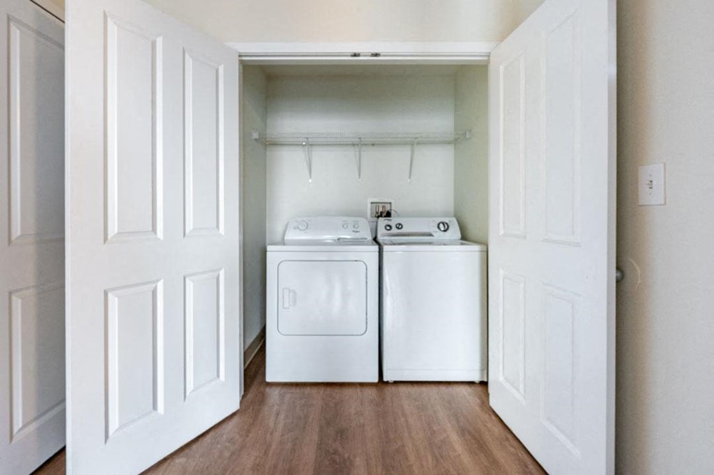 A white laundry room with a washer and dryer at The Cordovan at Haverhill Station, Haverhill, MA