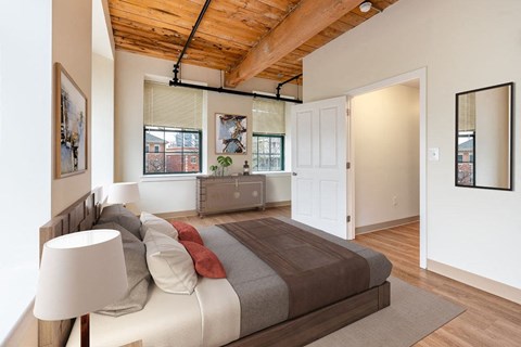 A bedroom with a bed and a lamp.