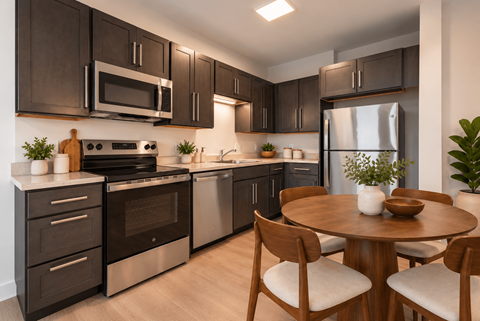 A modern kitchen with dark brown cabinets and stainless steel appliances at The Atwater at Ninth Square Apartments, New Haven, Connecticut