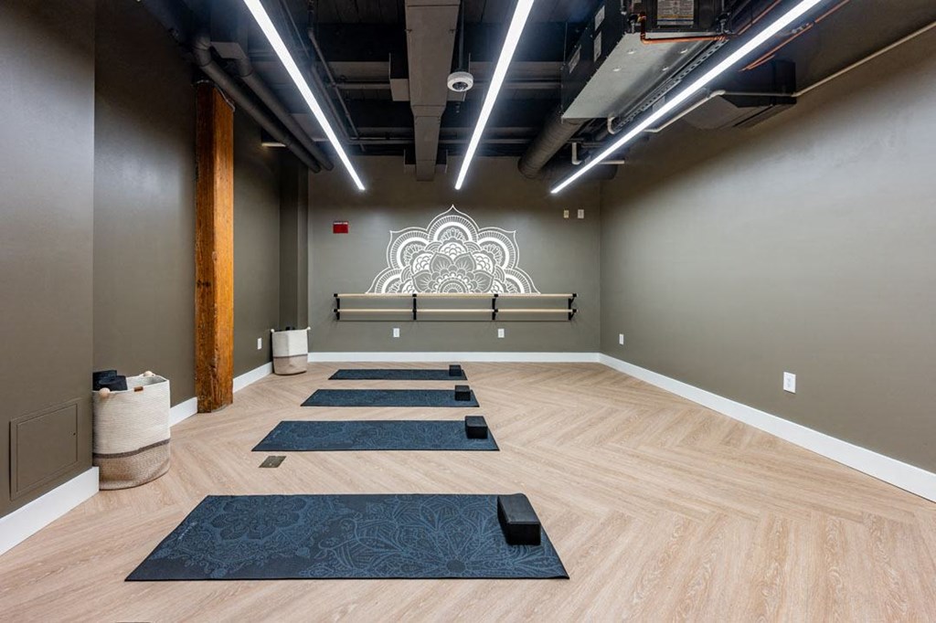 A yoga studio with wooden floors and mats at The Cordovan at Haverhill Station, Haverhill, MA