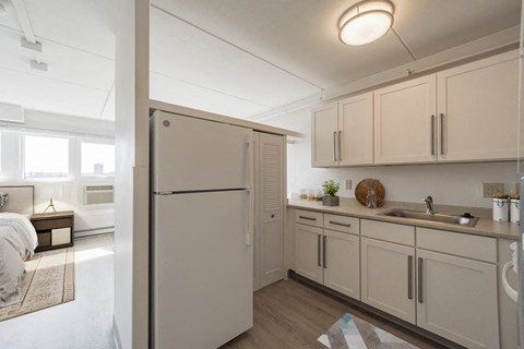 a kitchen with white cabinets and a white refrigerator