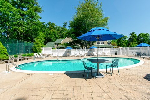 A blue umbrella is next to a pool table at at Mariner's Hill Apartments, Massachusetts.