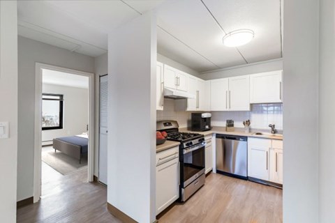 A kitchen with white cabinets and stainless steel appliances.