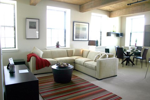 a living room with a white couch and a striped rug