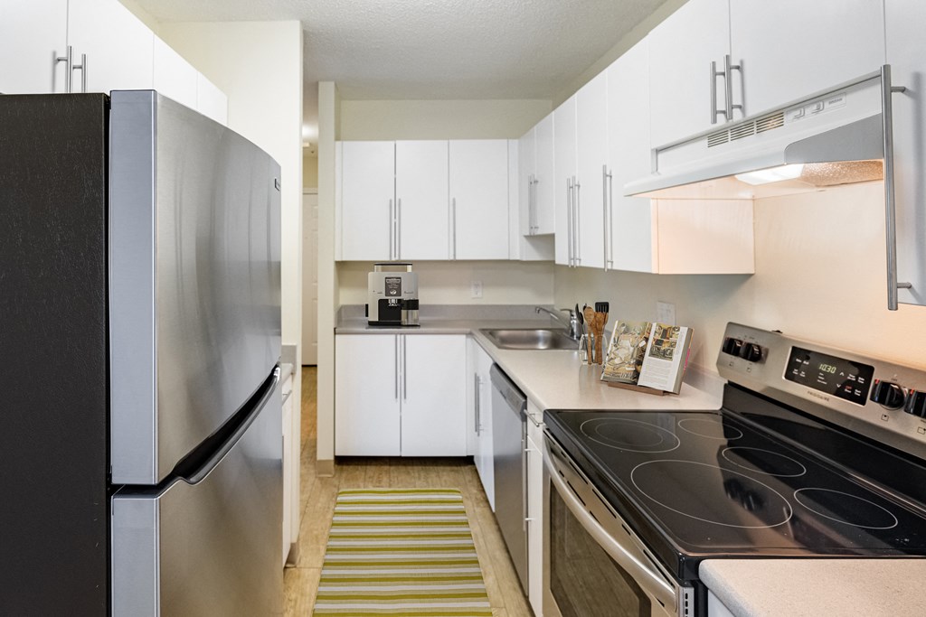 a kitchen with white cabinets and stainless steel appliances and a black stove at Blue Hills Village, Canton, 02021
