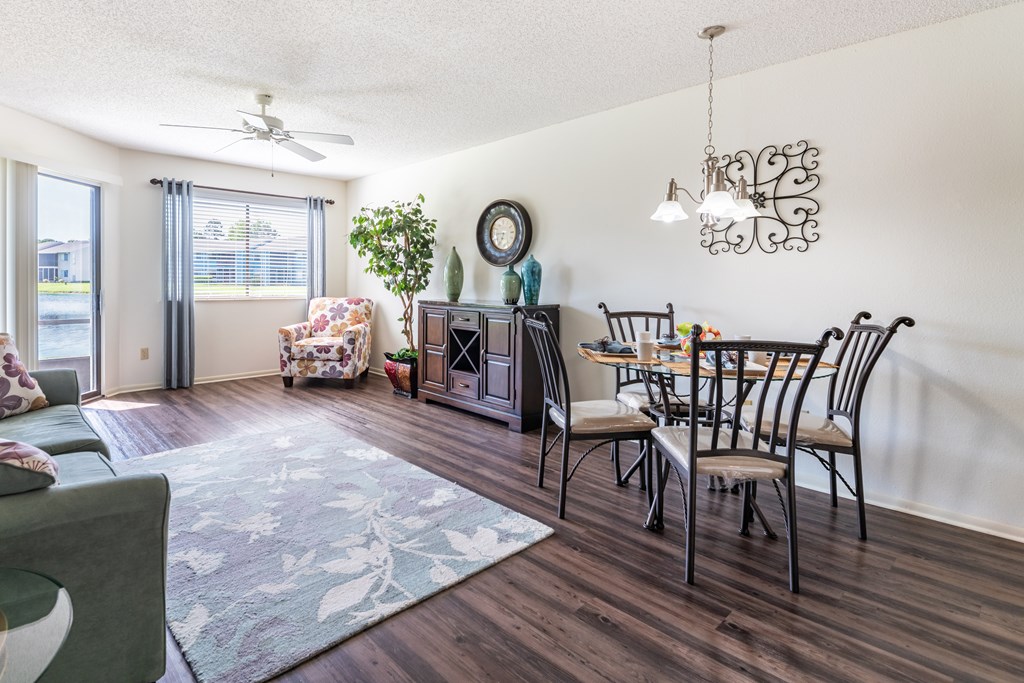 A living room with a dining table and chairs Fishermans Landing Apartments in Ormond Beach, FL.