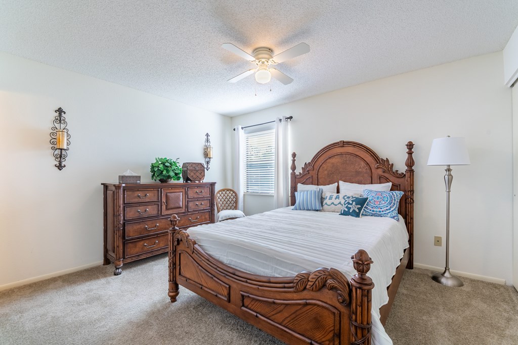 A bedroom with a large bed and a dresser Fishermans Landing Apartments in Ormond Beach, FL.
