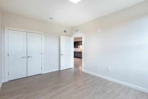 A bedroom with white walls and a white door at The Atwater at Ninth Square Apartments, New Haven, CT 06510