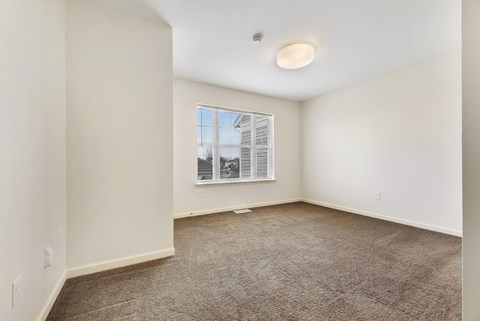 a bedroom with white walls and carpet at Creekwood Apartments, Watertown, NY