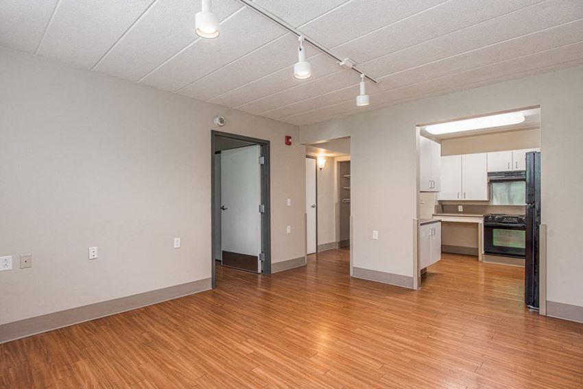 Open Floor Plan of One Bedroom Apartment with Hardwood Floors and Track Lighting.