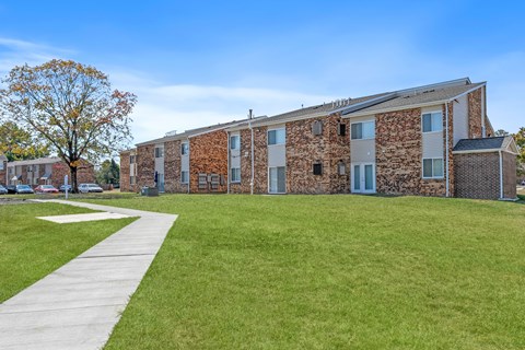 A building with a stone facade and a green lawn in front.