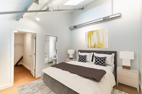 a bedroom with a large bed and a closetat Ames Shovel Works Apartments, North Easton, Massachusetts