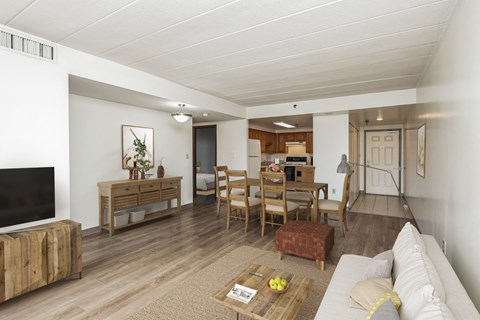 A living room with a white couch and wooden furniture.