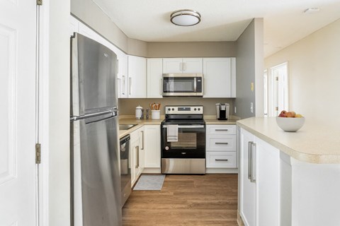 a kitchen with white cabinets and stainless steel appliances