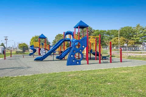 A playground with a blue slide and a red and yellow structure.