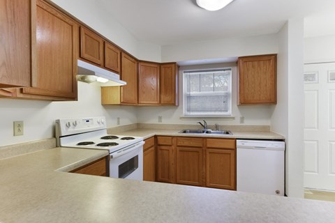 A kitchen with wooden cabinets and white appliances.
