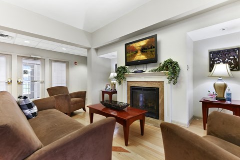 A living room with a fireplace and a painting on the wall.