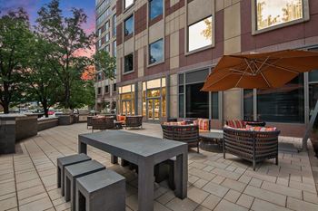 A patio with a table and chairs and a tree.