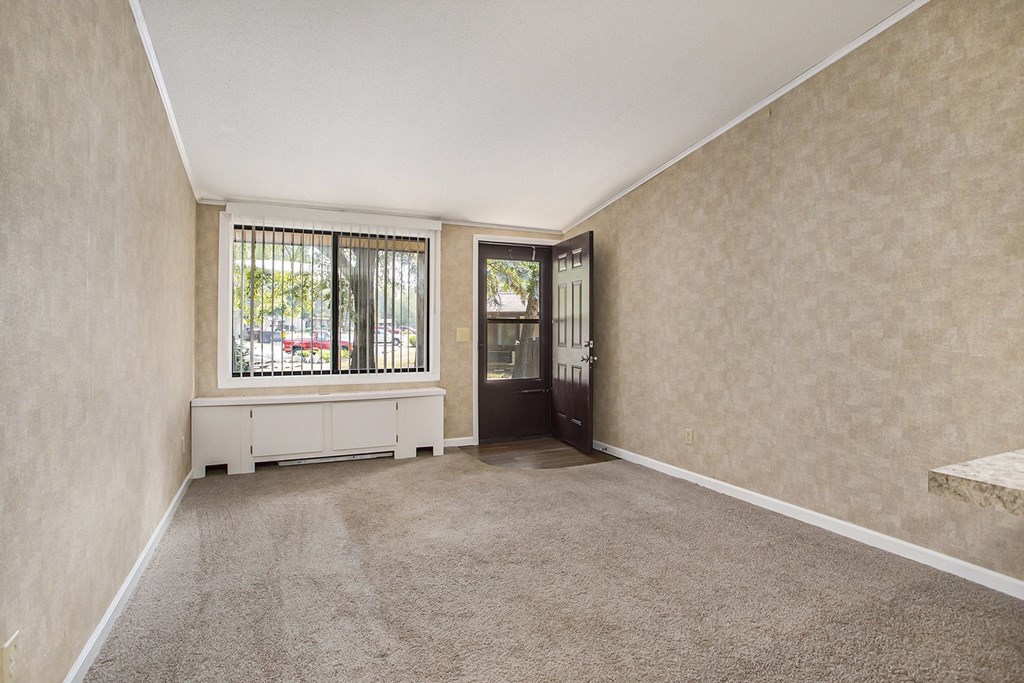a living room with beige walls and a large window