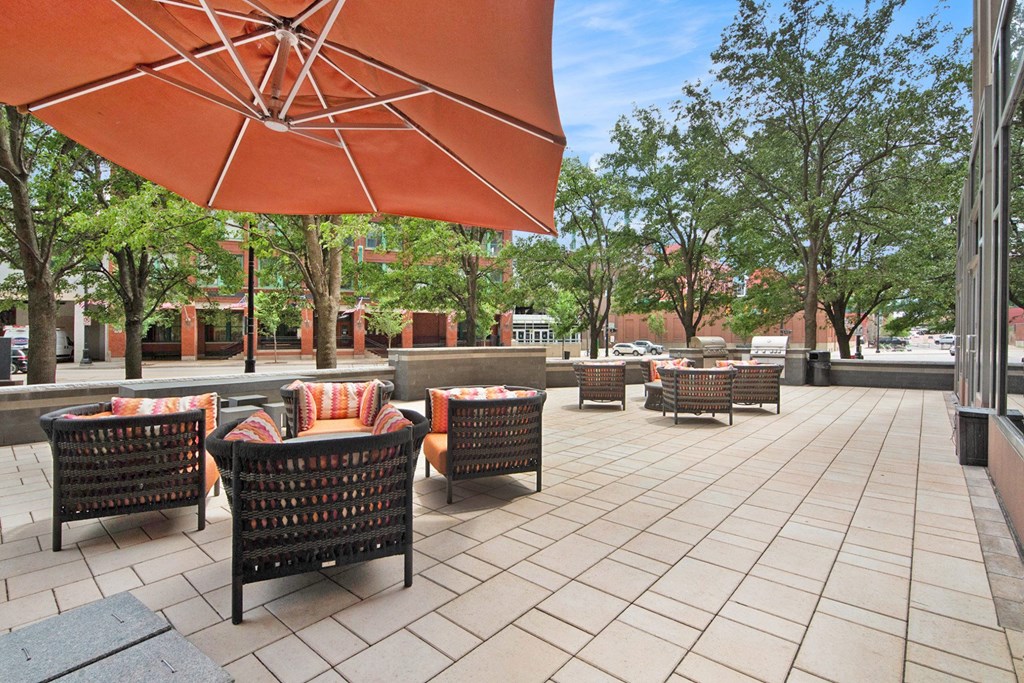 a patio with tables and chairs and an umbrella