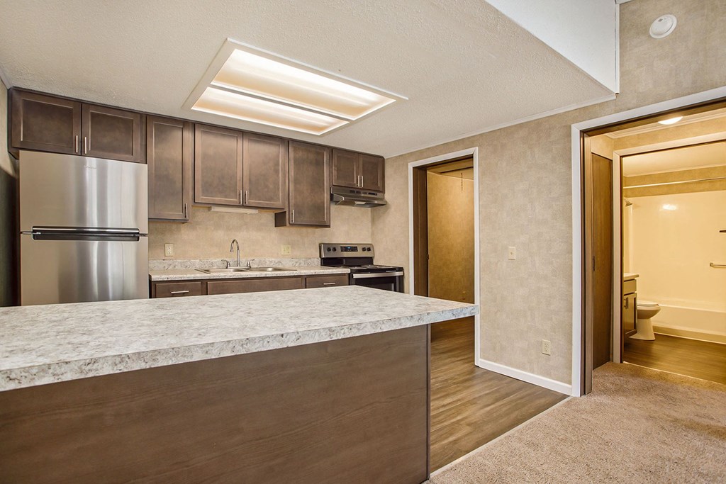 a kitchen with a large island and stainless steel appliances