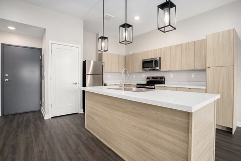 A modern kitchen with a white countertop and wooden cabinets.