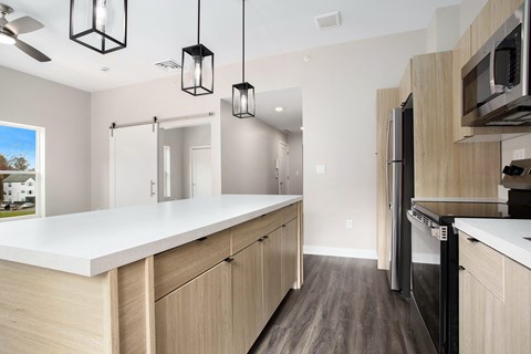 A modern kitchen with a white countertop and wooden cabinets.
