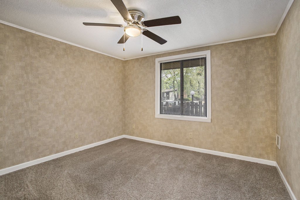 a bedroom with a ceiling fan and a window