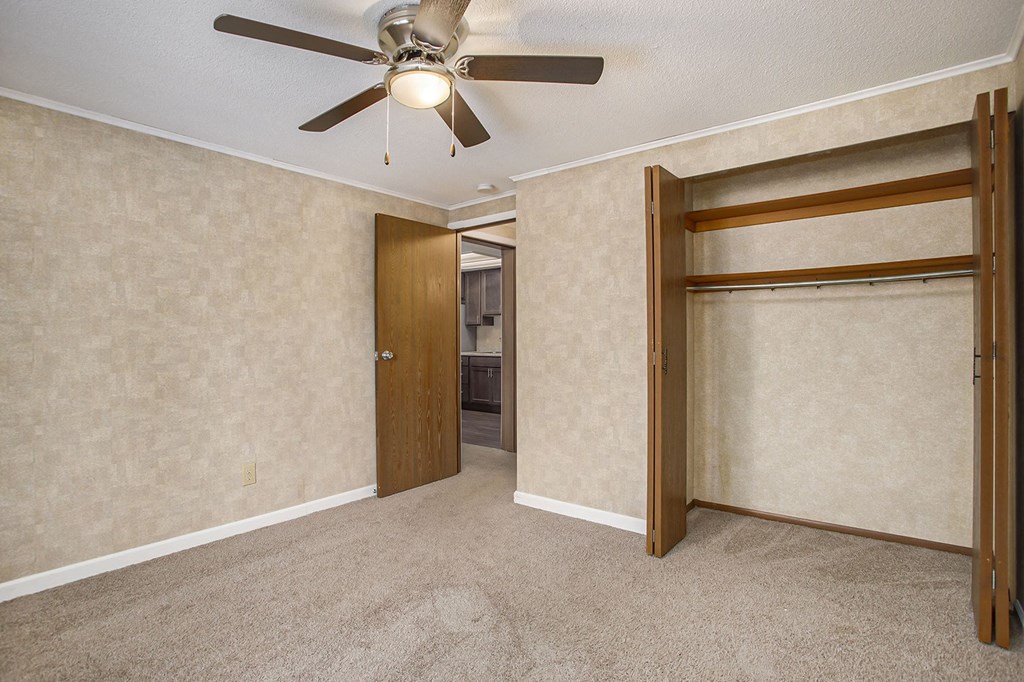 a bedroom with a ceiling fan and a closet