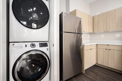 A modern kitchen with a washing machine and refrigerator.