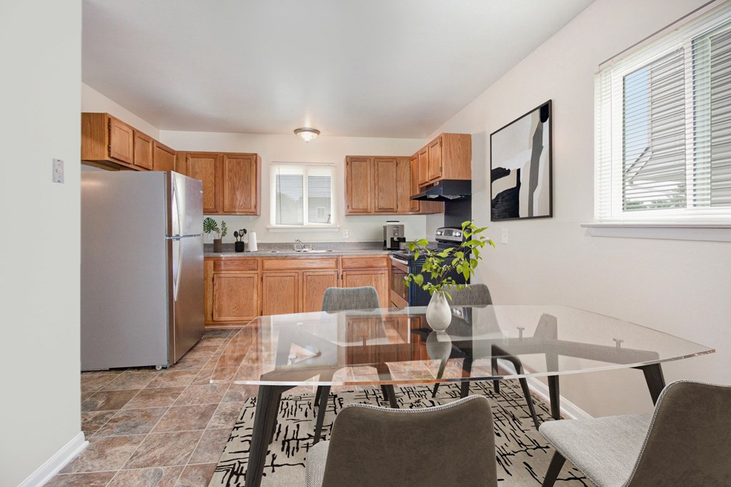 a kitchen and dining room with a glass table and chairs
