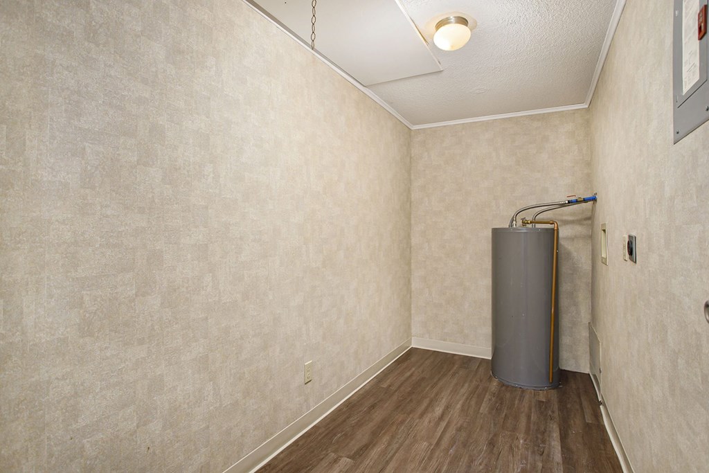 a room with a water heater in the corner