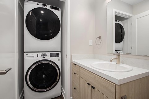 A white front loading washing machine in a small bathroom.