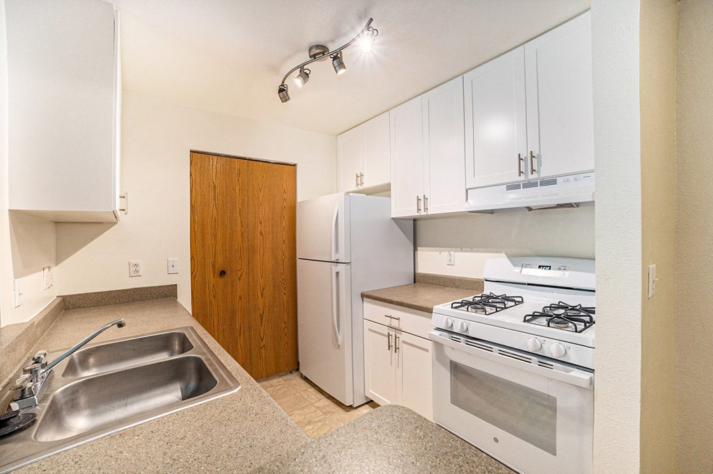 a kitchen with white cabinets and white appliances