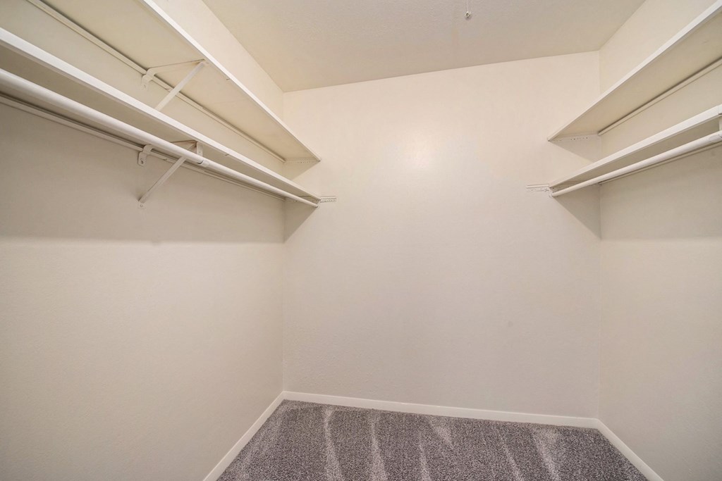 an empty room with white walls and two shelves on the wall