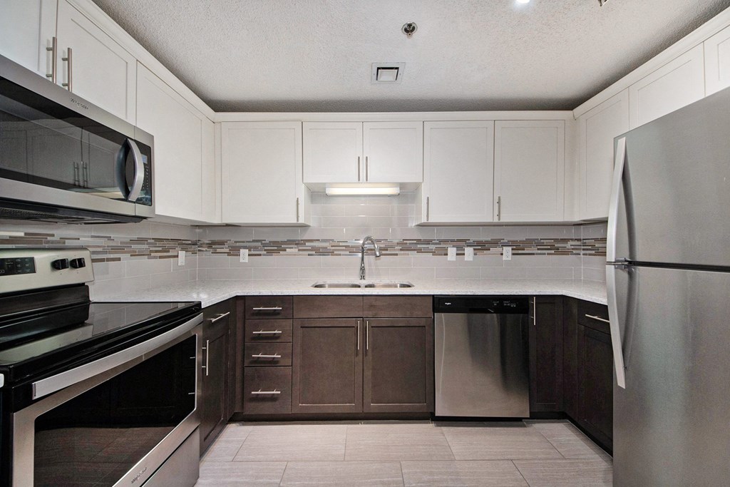 a kitchen with white cabinets and stainless steel appliances