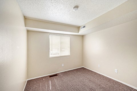 a bedroom with white walls and carpet