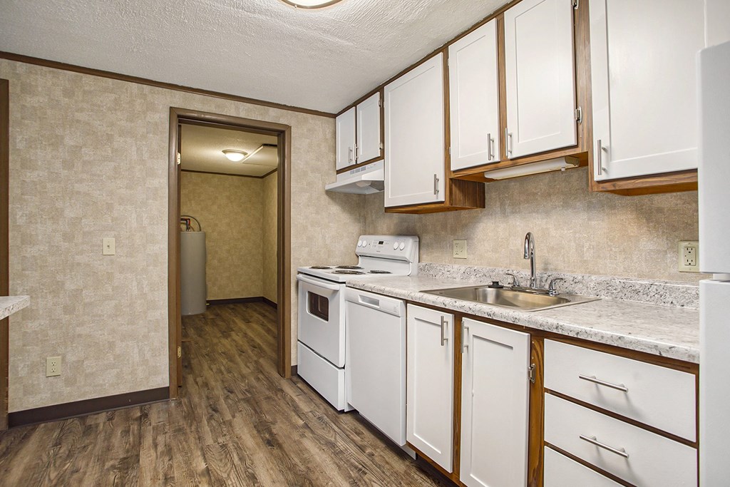 a kitchen with white cabinets and a white dishwasher
