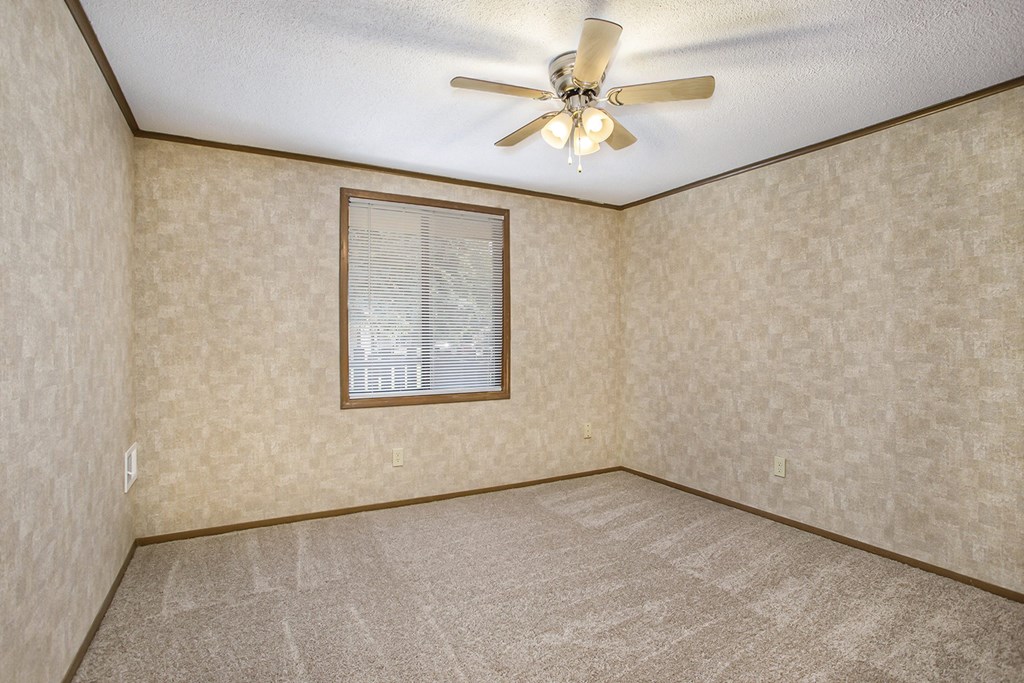 a living room with a ceiling fan and a window