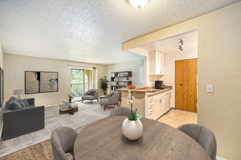 a living room with a dining room table and a kitchen