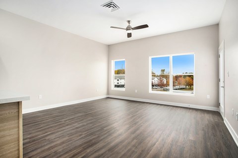 Empty room with a ceiling fan and three pictures on the wall.