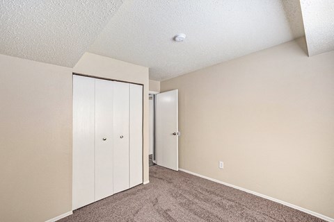 a bedroom with beige walls and a carpeted floor