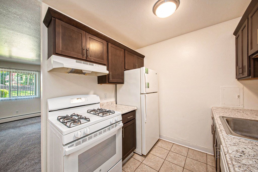 a kitchen with white appliances and brown cabinets