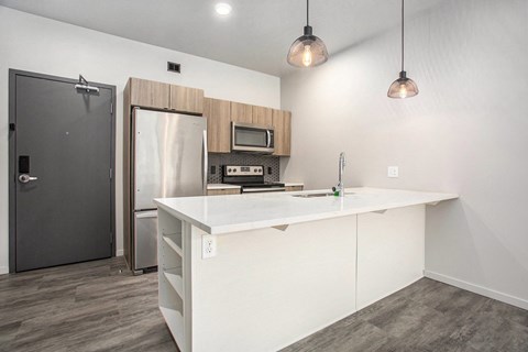 a white kitchen with a stainless steel refrigerator and a sink