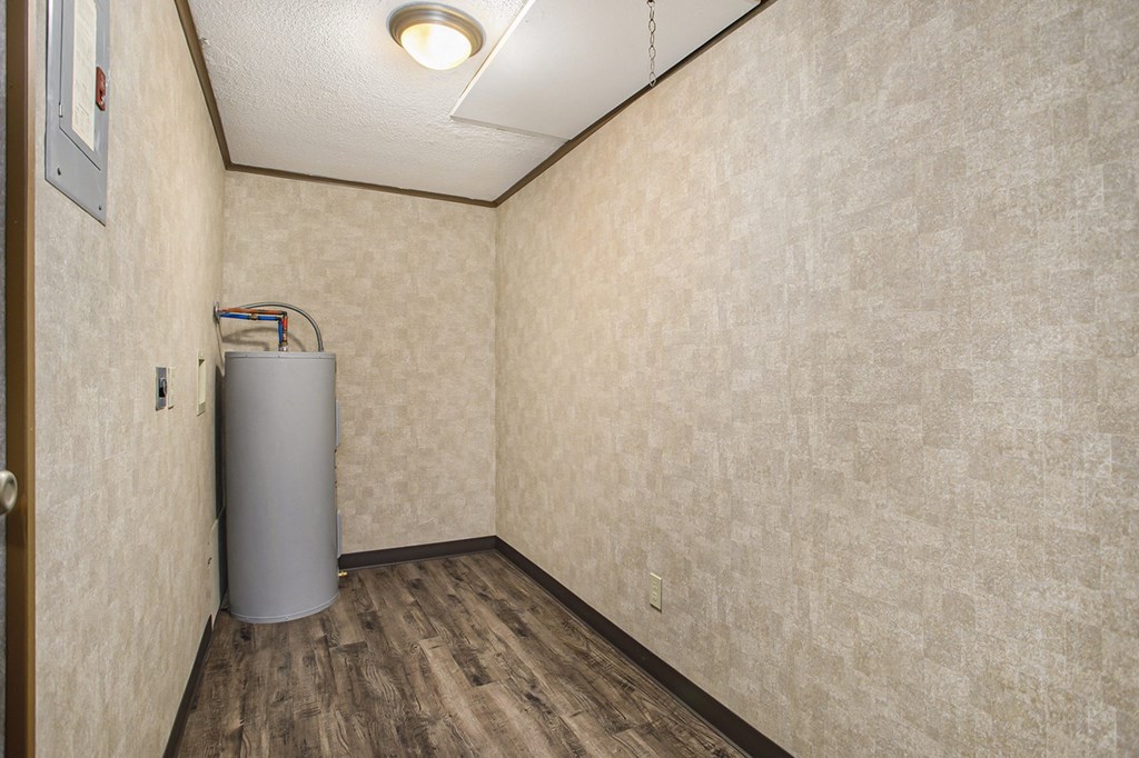 a small room with a water heater in the corner