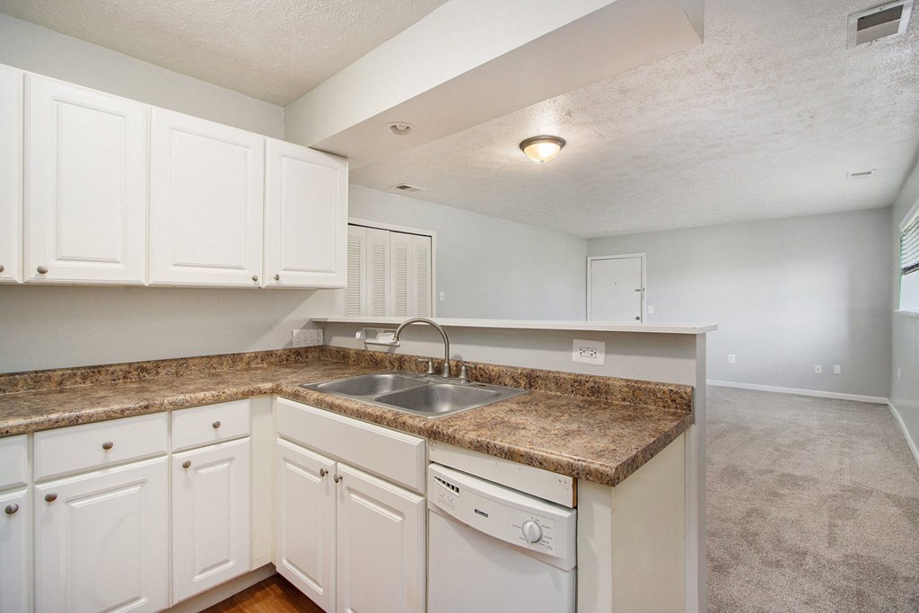 a kitchen with white cabinets and a granite counter top
